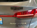 the rear end of a silver car with a sticker on it ' s bumper