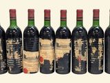 six bottles of red wine are lined up in a row