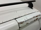 a close up of a white car with rust on it