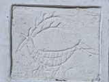 relief représentant un oiseau sur un bloc de pierre fixé à un mur