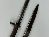 pair of old knives on a white surface with a black handle