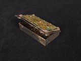 a close up of a small metal box on a black surface