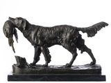 a bronze statue of a dog with a bird in its mouth