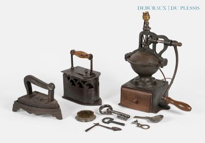 une petite collection d'ustensiles de repassage anciens posés sur une surface blanche