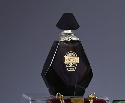 a bottle of perfume sitting on top of a suitcase