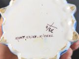 a person holding a white and blue vase with writing on it