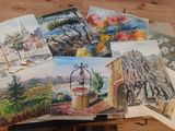 a lot of paintings that are on a table