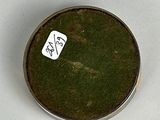 a small metal container with a tag on top of it