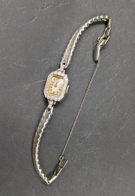 un gros plan d'une montre attachée à une chaîne, posée sur une table