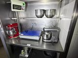 a kitchen with a metal counter and a mixer on it