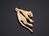 a gold cat broochle on a black background