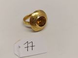 une image représentant une bague en or sertie d'une pierre marron