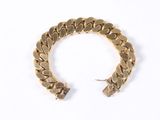 a close up of a gold bracelet on a white surface
