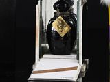a small bottle of perfume sitting on a table next to a box
