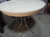 une table blanche avec un piètement en métal dans une pièce