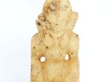 une image représentant une petite statue d'une personne assise sur une surface blanche