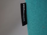 a close up of a blue pillow with a black label on it