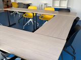 tables and chairs in a room with blue carpet and yellow chairs