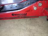 l'arrière d'une machine rouge sur laquelle est inscrit « dragkar equipment »