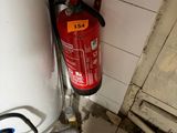 a fire extinguisor in the corner of a bathroom