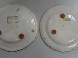 two white plates with brown spots on them sitting on a table