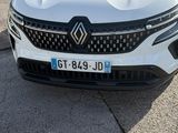 a white car parked in a parking lot next to a fence