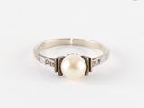bague en perles blanches et diamants sur fond blanc