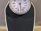 a black and white bathroom scale with a clock on it