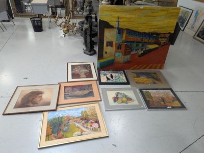 many paintings on the floor in a room