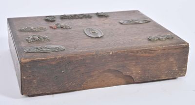 a small wooden box with metal buttons on it