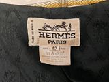 the label on a black dress with a yellow and white pattern