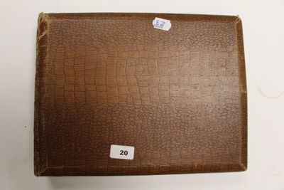 une valise marron avec une étiquette, posée sur une table