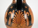 a black and orange vase sitting on a white surface