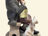 a figurine of a man sitting on a bench with a dog