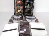 several bags of coffee sit on a table next to a bag of coffee