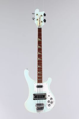 une guitare électrique blanche suspendue à un fil accroché au mur