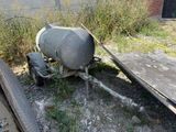 a cement mixer sitting on the ground next to a trailer