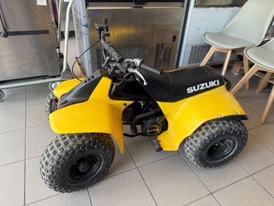 a small yellow four wheeler motorcycle parked in a room