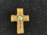 a close up of a cross on a black surface