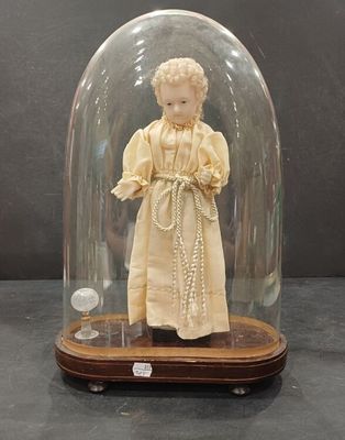 une figurine représentant une femme en robe, placée sous un dôme en verre