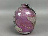 a purple vase with a design on it on a table