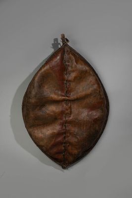 un vieux sac à main en cuir accroché au mur à l'aide d'un crochet