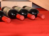 several bottles of wine are lined up on a red table cloth
