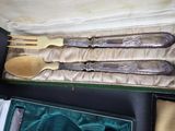 three silverware in a case with a gold spoon and fork