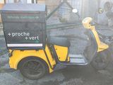 a yellow scooter with a box on the back of it