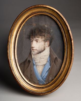 portrait d'un homme vêtu d'un manteau marron et d'une écharpe bleue