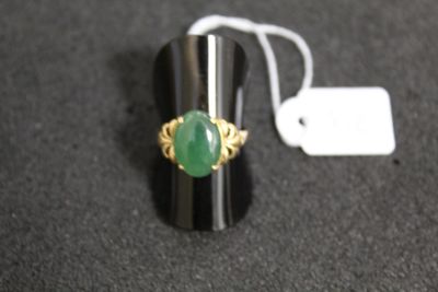une bague sertie d'une pierre verte, posée sur une table