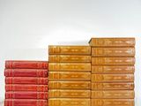 several books stacked on top of each other on a white surface