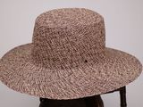 une image représentant un chapeau marron posé sur une chaise