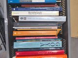 a stack of books sitting on top of a metal rack